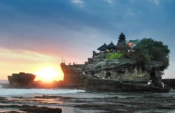 Maisons sur un rocher en bord de mer et coucher de soleil en Indonésie