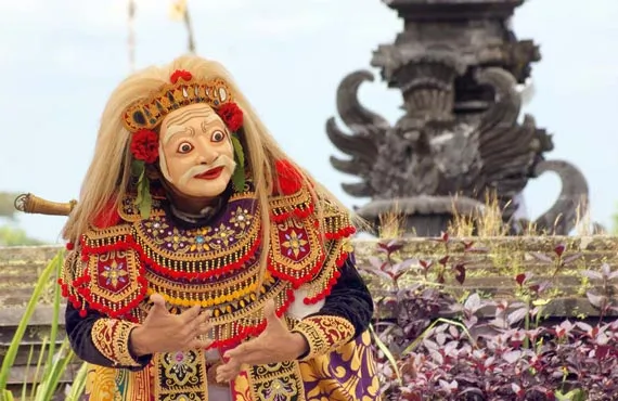 Homme vetu d'un costume coloré et d'un masque dans le temple de Besakih en Indonésie