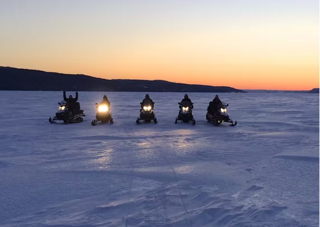motoneiges au coucher de soleil au Canada