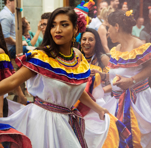 Danseuse colombienne en robe blanche et col de couleur pendant le carnaval d'été