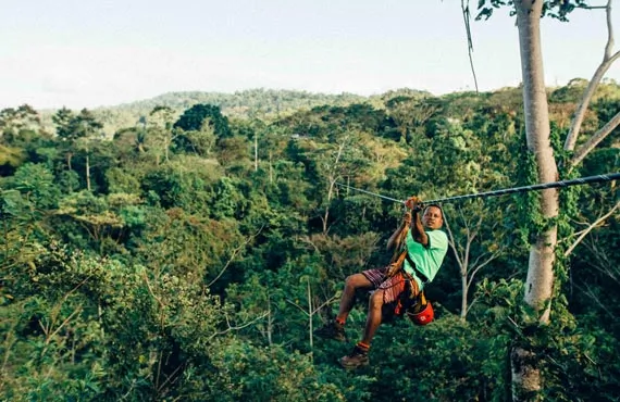 Homme sur une tyrolienne au dessus de la forêt au Costa Rica