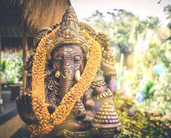 Statue de déesse éléphant couverte d'un collier de fleurs