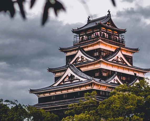 Temple gris et orange entouré d'arbres au Japon