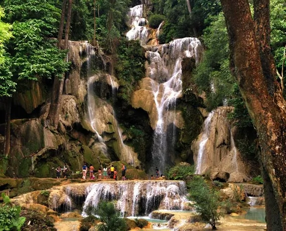 Groupe de personnes sous une cascade formant des bassins dans une forêt au Sri Lanka