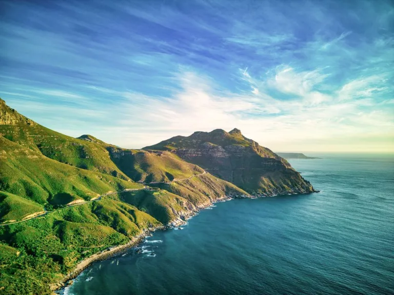 Vue aérienne de la Chapman’s Peak Drive route panoramique longeant la côte entre montagnes verdoyantes et océan Atlantique, Afrique du Sud.