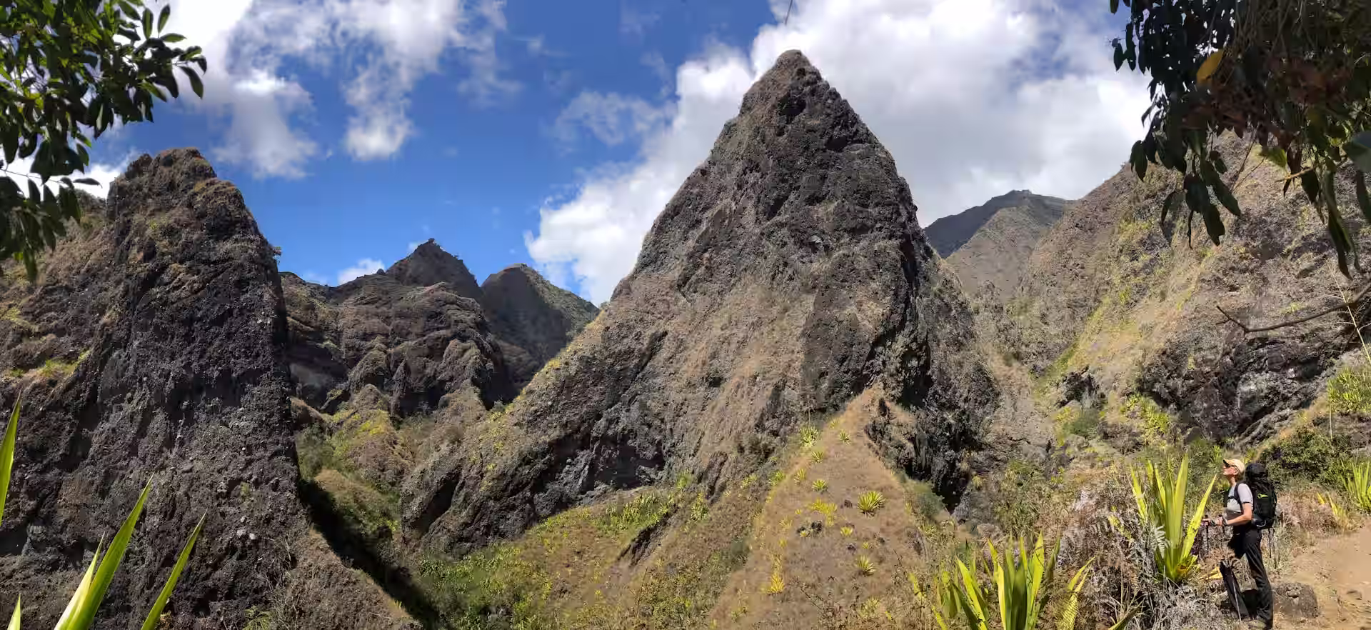 Randonneuse sur un chemin parmi les reliefs escarpés du cirque de Mafate à La Réunion