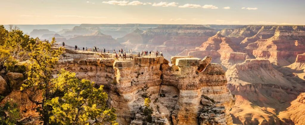groupe de personnes sur un promontoire face aux reliefs du grand Canyon, Etats-Unis