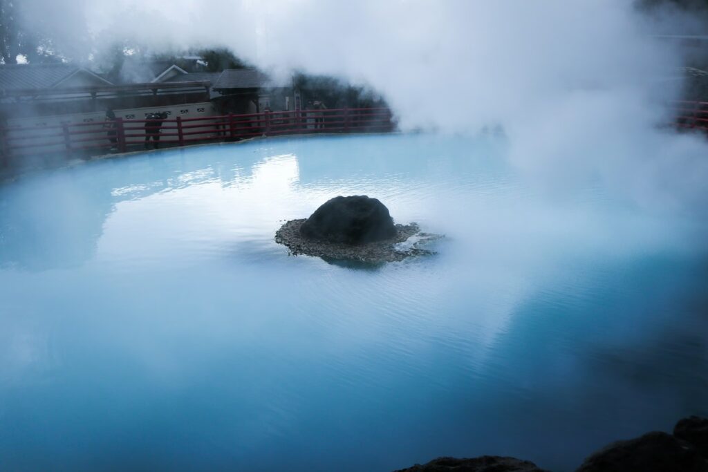 Source chaude onsen, ryokan, aux couleurs bleutées dégageant de la vapeur à Beppu, Japon.