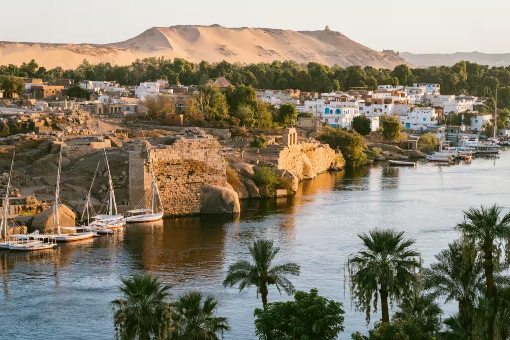 Dunes de sable, palmiers et bateaux sur le Nil à Assouan, Egypte