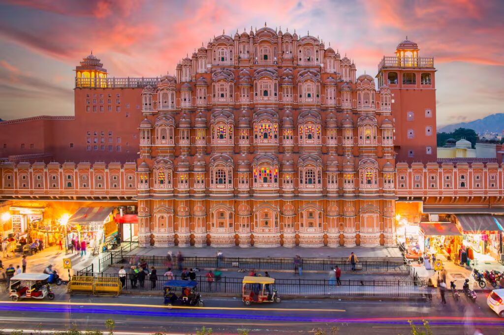 Vue imprenable sur le Hawa Mahal (palais des vents) au coucher du soleil avec des gens flous marchant devant. Jaipur, Inde.