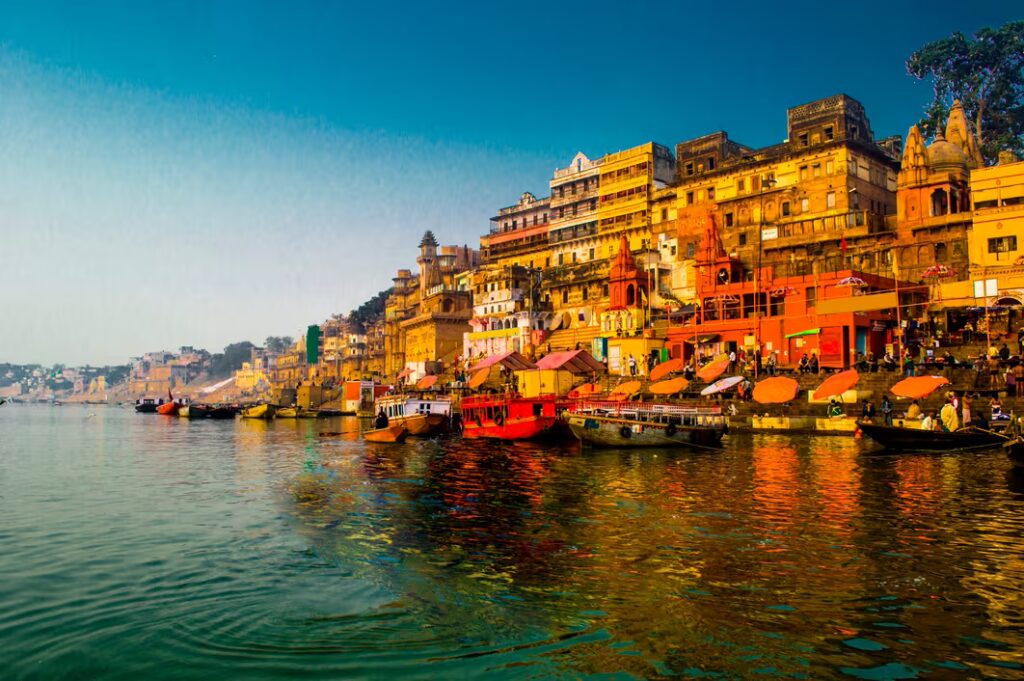 Ghats de Varanasi au bord du Gange, avec temples colorés, marches sacrées et barques traditionnelles sur le fleuve, Inde du Nord