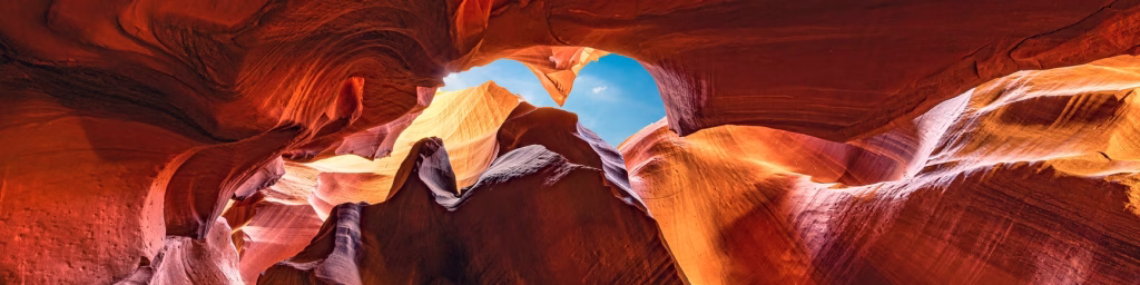 Contre plongée des grès d'Antelope Canyon qui laisse apparaitre le ciel bleu
