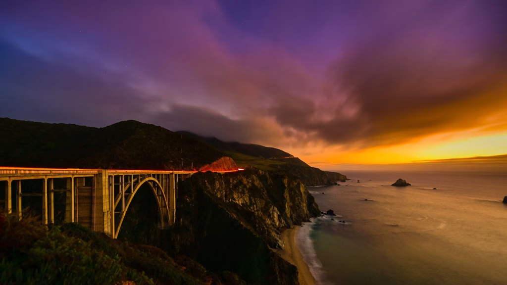 Vue panoramique de la Highway 1 au niveau du Bixby Bridge suspendue aux montagnes au coucher du soleil, Californie