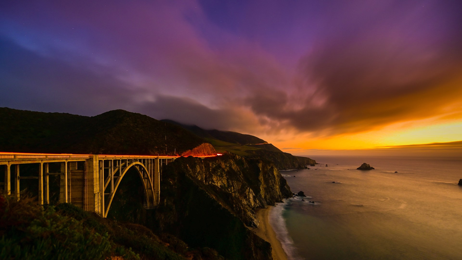 Vue panoramique de la Highway 1 au niveau du Bixby Bridge suspendue aux montagnes au coucher du soleil, Californie