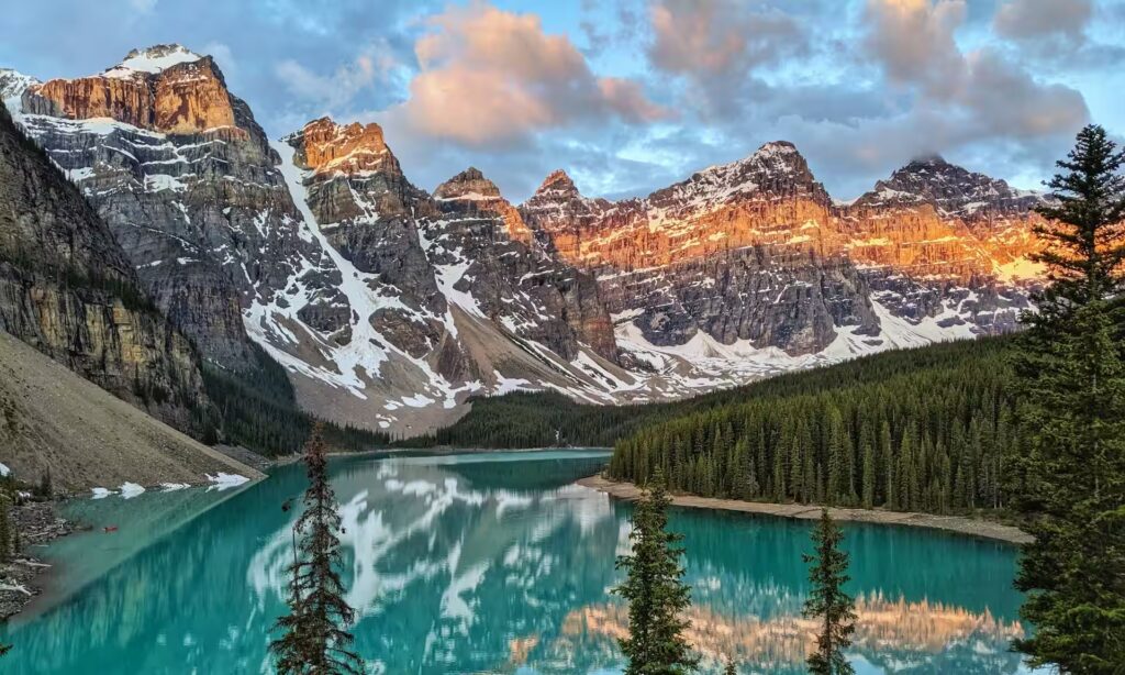 lac entouré de montagnes enneigées et de grands arbres, canada