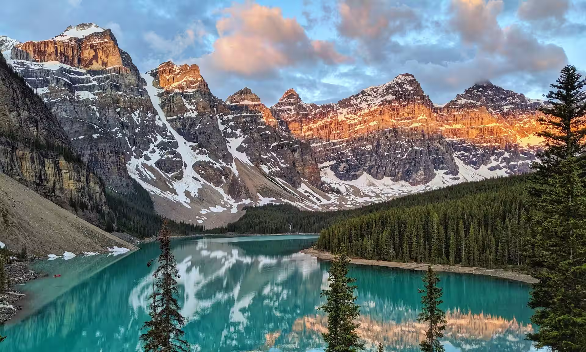 lac entouré de montagnes enneigées et de grands arbres, canada