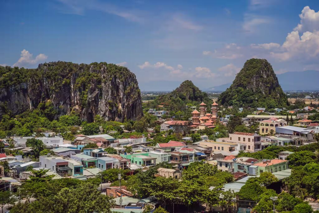 Villes de maisons colorés entourée de végétation et de pains kartisques recouverts de végétation, Vietnam