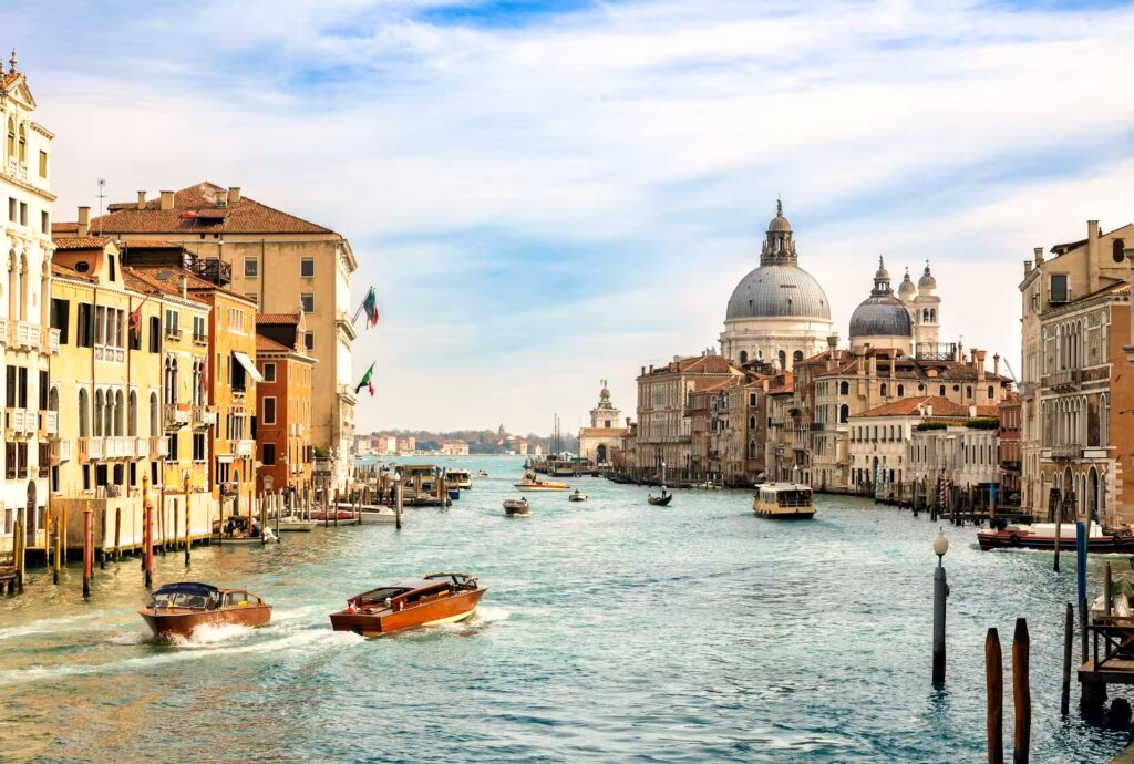 Vue du grand canal à Venise bordé de palais anciens, avec bateaux et vaporetto circulant sur ses eaux - Venise, Italie