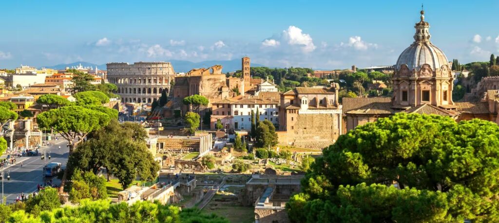 Vue sur la ville de Rome avec des arbres au premier plan, des vestiges romains et le Colisée, Rome, Italie