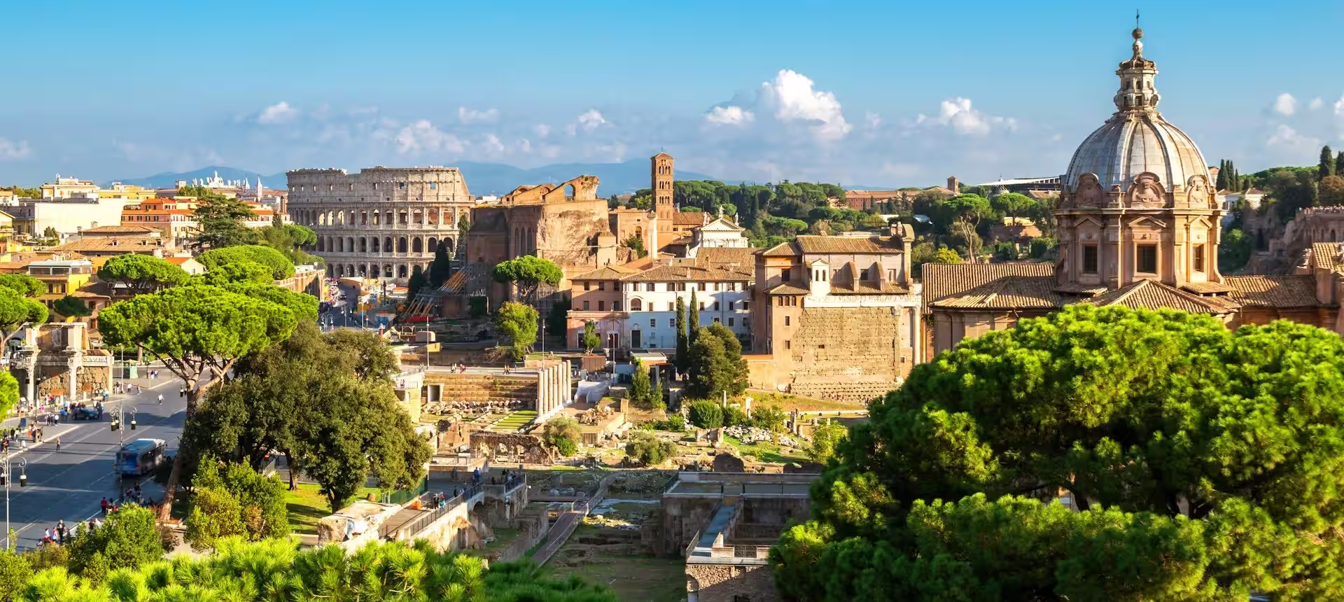 Vue sur la ville de Rome avec des arbres au premier plan, des vestiges romains et le Colisée, Rome, Italie