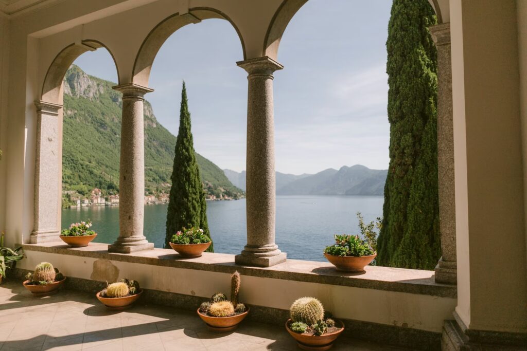 Vue sur le lac depuis une veranda avec pots de fleurs et cactus