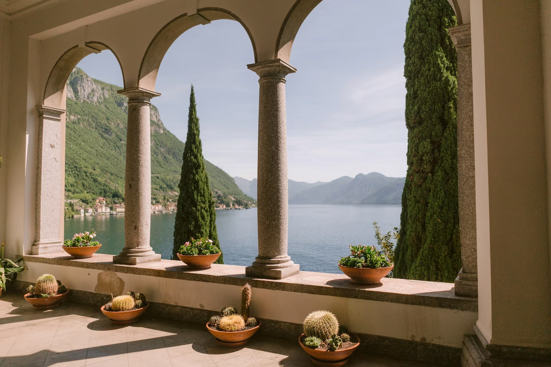 Vue sur le lac depuis une veranda avec pots de fleurs et cactus