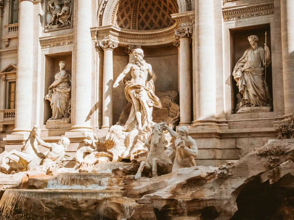 Eau coulant de statue et façade décorée de statues et colonnes