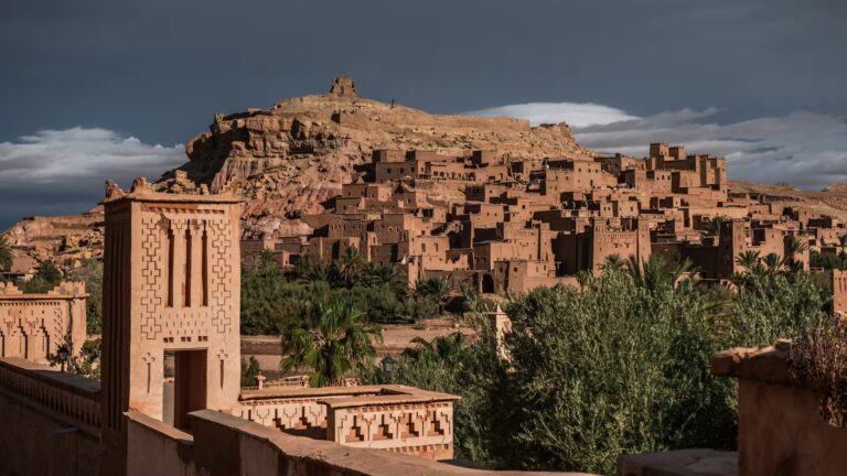 Ville aux batiments en pisé, couleur terre avec végétation et montagne