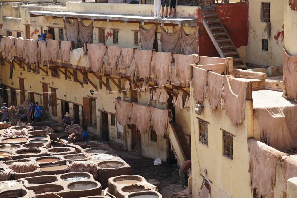 Linge qui seche sur les toit et mur des habitations avec les cuves remplies de liquides colorés