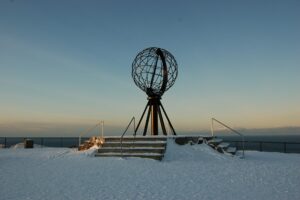 Sculpture sphérique planté dans la neige à côté de la mer