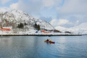 Deux personnes faisant du kayak et montagnes enniegées