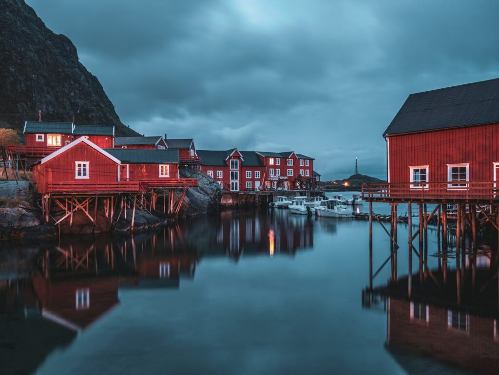 Maisons rouges en bois sur pilotis avec bateaux