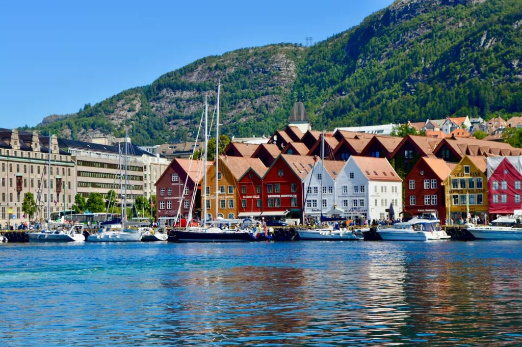 Vue depuis l'eau sur batimnts colorés, bateaux et montagne