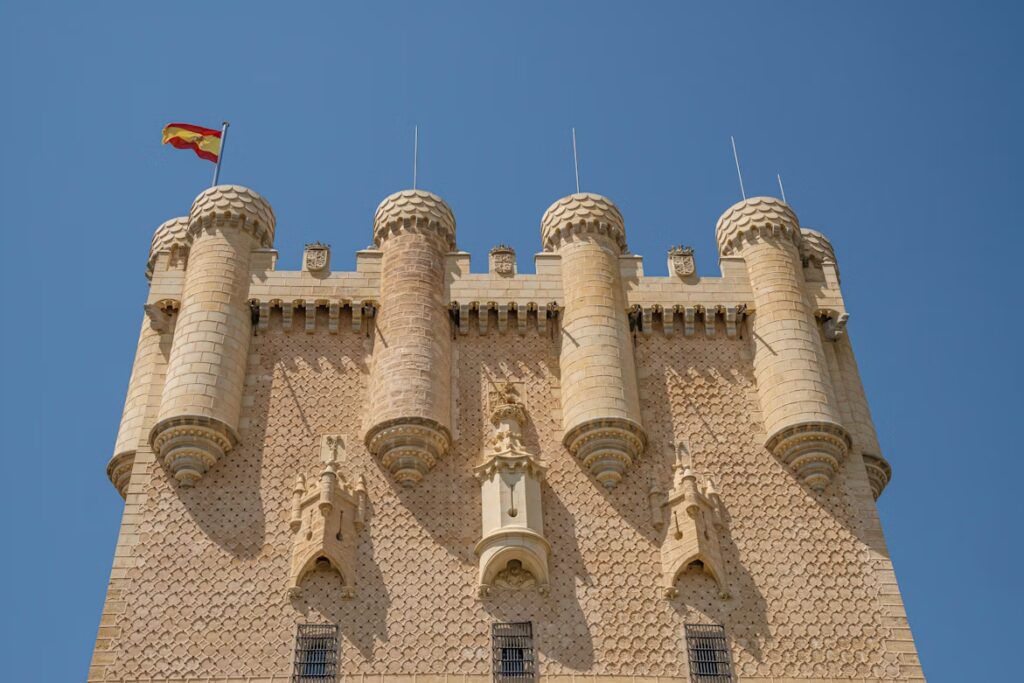 grande tour ornée d'un drapeau jaune et rouge et des tourelles sculptées