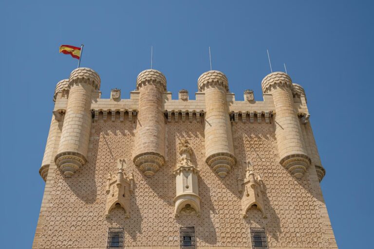 grande tour ornée d'un drapeau jaune et rouge et des tourelles sculptées