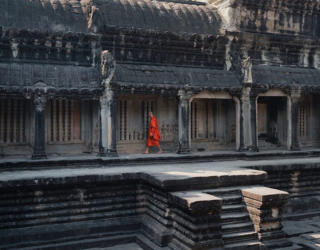 Moine marchant dans une allée d'arcades d'un temple
