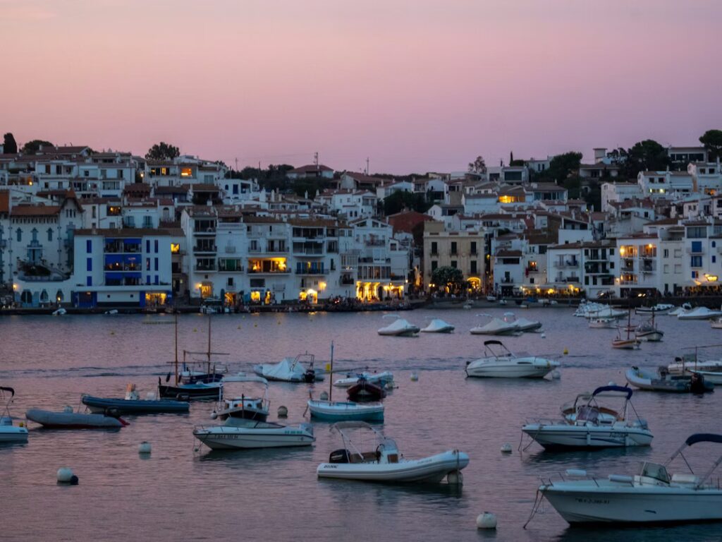 Port avec bateaux amarrés dans la lumiere du soir et habitations eclairées sur les quais
