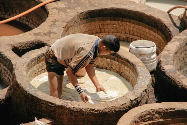 Homme dans un bassin rempli d'eau blanchâtre faisant baigné de la peau de bête