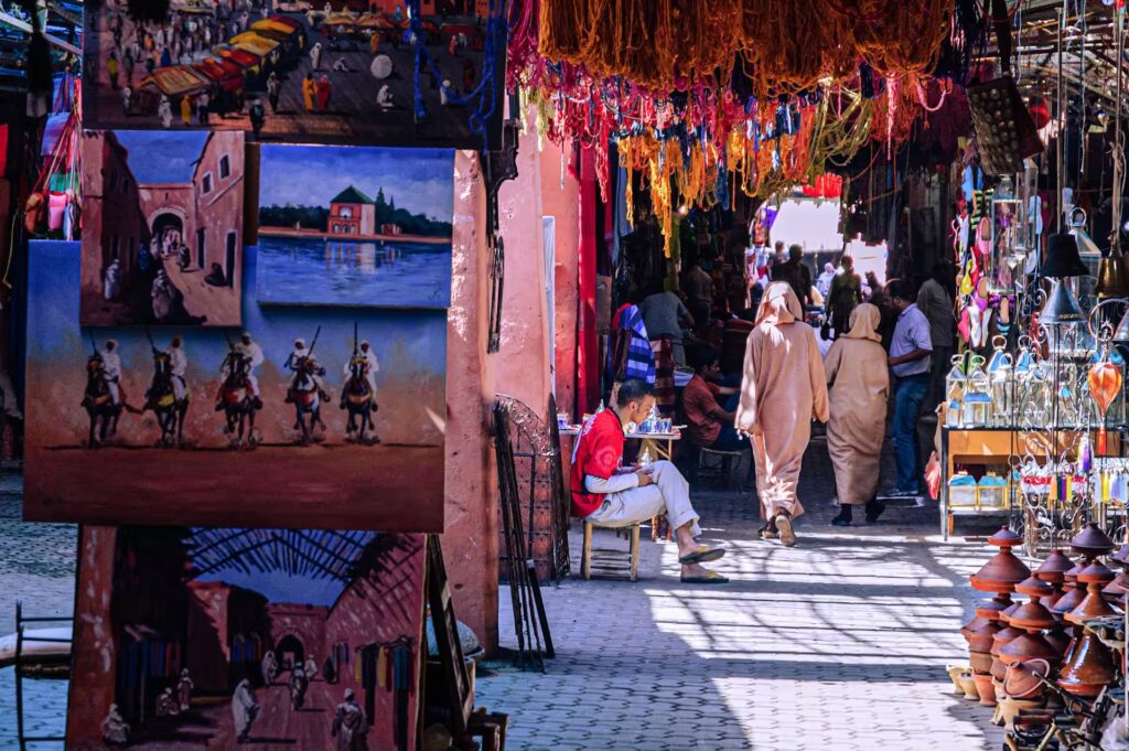 Ruelle du marché avec plusierus étal vendant peintures, lampes, textiles, tajine