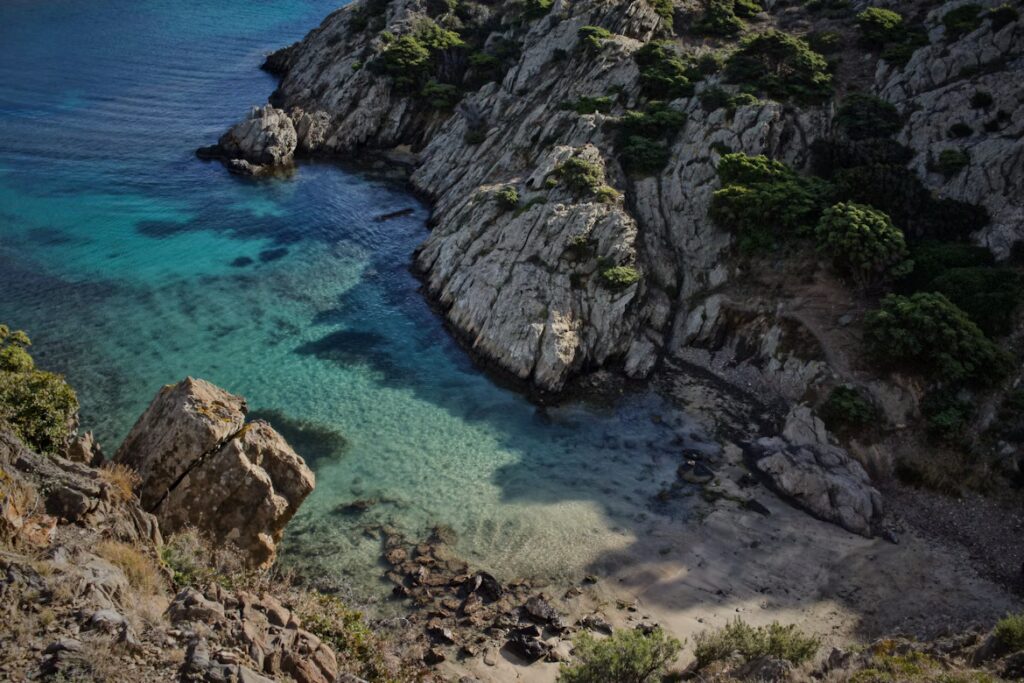 Crique eau clair, mini plage de sable blanc, falaises rocheuses