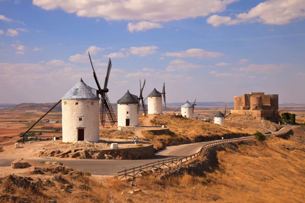 paysage de plaine avec 5 moulins à vent et le chateau de Consuegro, région de Tolède, Espagne