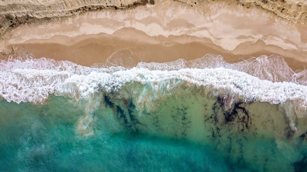Vue du ciel sur plage de sable blanc et eaux turquoises