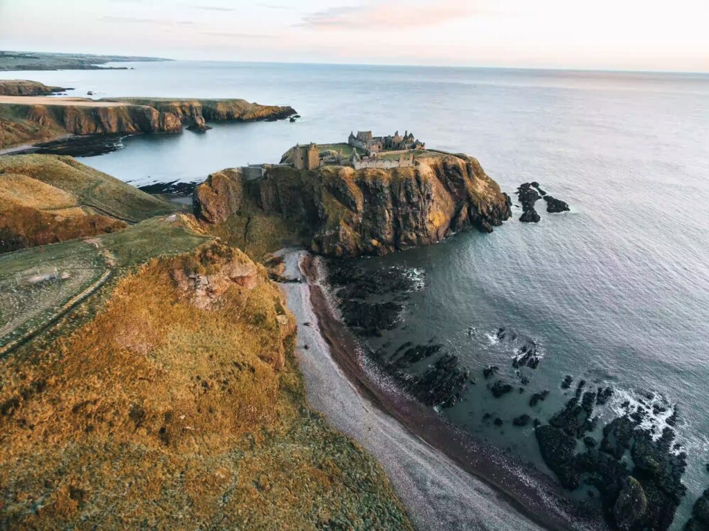 Vue sur une presqu'ile avec un chateau en ruine, les falaisais et la mer