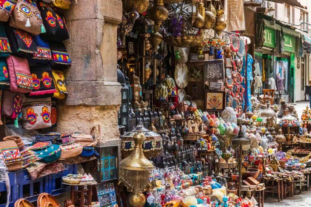 Etal de vente de luminaires colorés, de sacs à mains brodés et colorés le long d'une façade