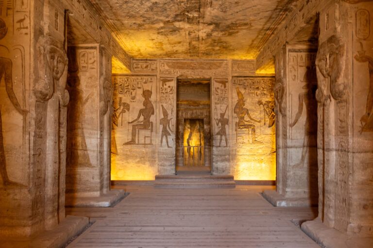 Entrée dans un temple avec mur gravés de dessins et de hieroglyphes, éclairés par lumiere du sol