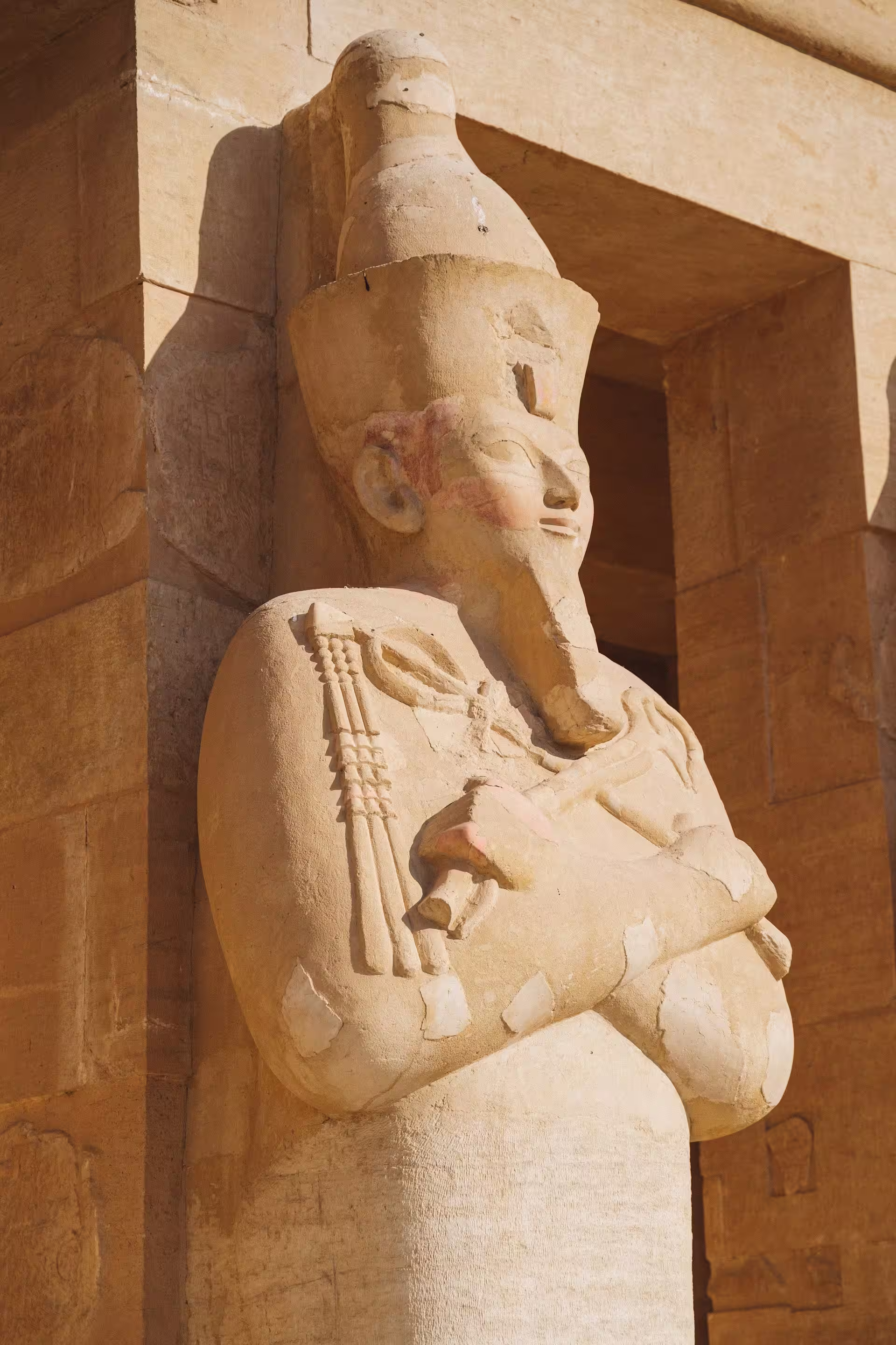 Statue contre un mur representant un pharaon