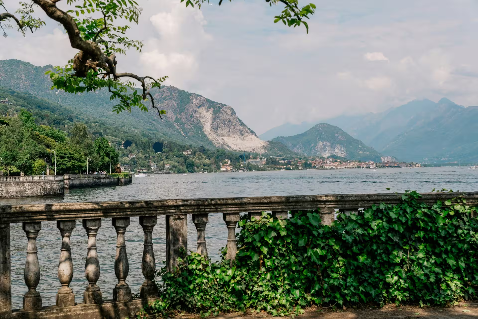 Balustrad en pierre recouverte de végétation, au dessus de l'eau, Côte et montagnes de la rive du lac