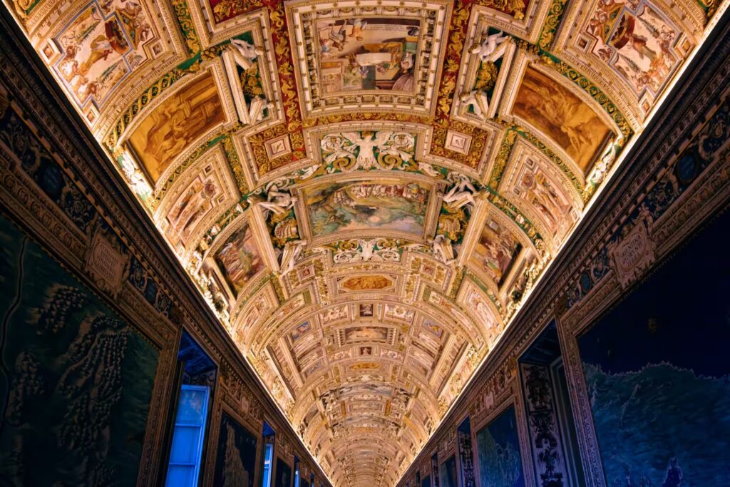 Plafond orné de peintires eclairées dans une salle longue