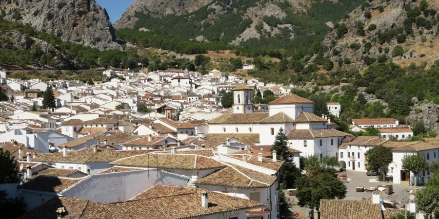 une vue dun village aux façades blanches avec des montagnes en arriere plan