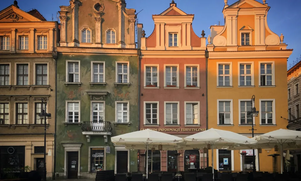 une rangee de batiments avec des tables et des parasols devant eux